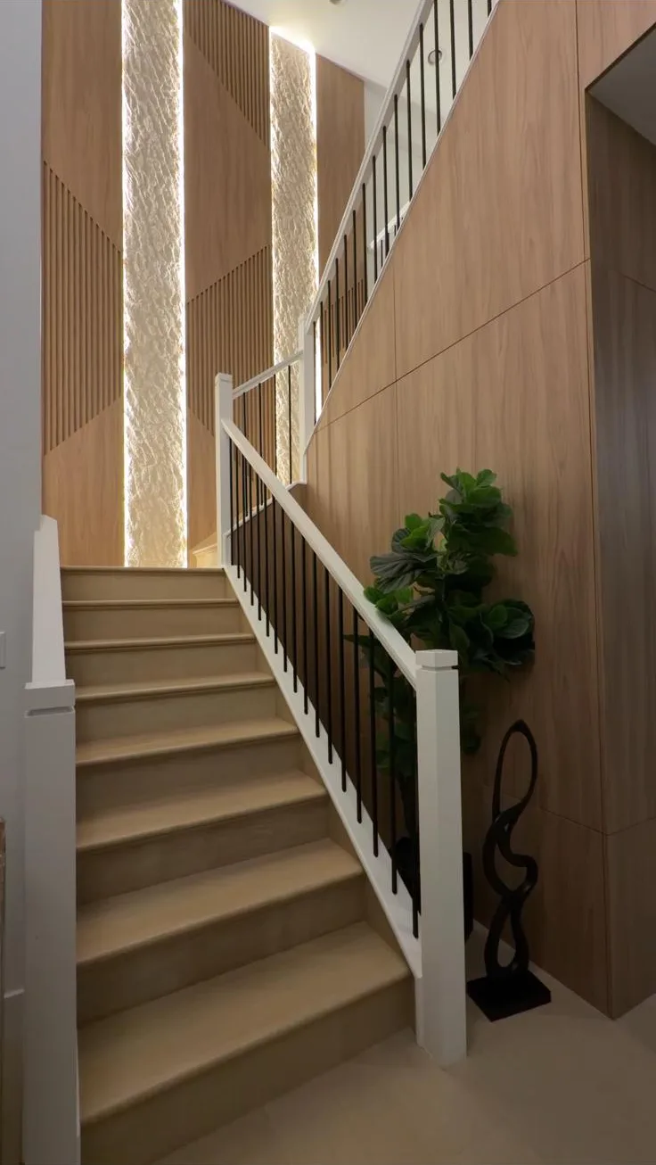 Staircase with walnut slat wall, backlit stone columns and oak treads